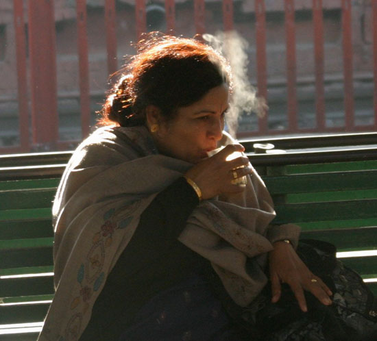 indian woman drinking tea at train station